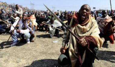 Striking South African miners armed with homemade spears and pangas chant slogans near Marikana platinum mine in Rustenburg, South Africa, on Thursday, August 16.