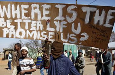 A jobless protester holds a placard during a 2009 march in the Ramaphosa squatter settlement, east of Johannesburg